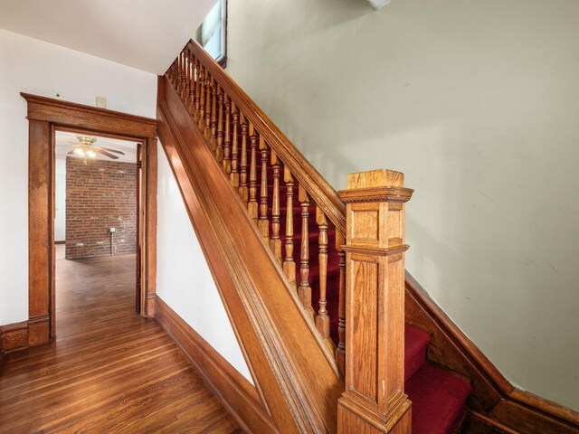 1360 S High St, Columbus, OH 43207 - stairs with wood finished floors, brick wall, and ceiling fan