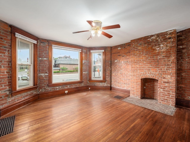 1360 S High St, Columbus, OH 43207 - unfurnished living room featuring hardwood / wood-style floors, a brick fireplace, a ceiling fan, and brick wall