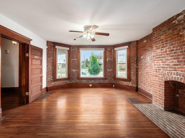 1360 S High St, Columbus, OH 43207 - unfurnished living room with hardwood / wood-style floors, ceiling fan, and brick wall