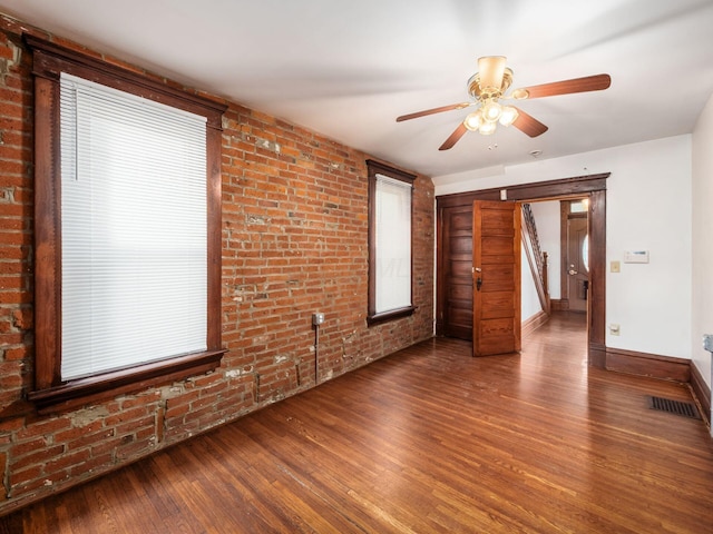 1360 S High St, Columbus, OH 43207 - unfurnished living room featuring brick wall, wood finished floors, and a ceiling fan