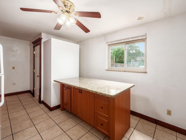 1360 S High St, Columbus, OH 43207 - kitchen with a ceiling fan, brown cabinetry, light tile patterned floors, and light stone countertops