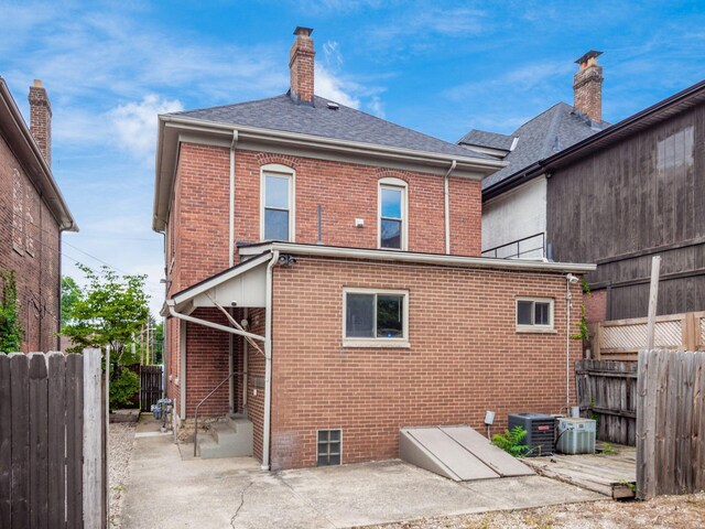 1360 S High St, Columbus, OH 43207 - back of property with brick siding, a chimney, a patio area, and a shingled roof