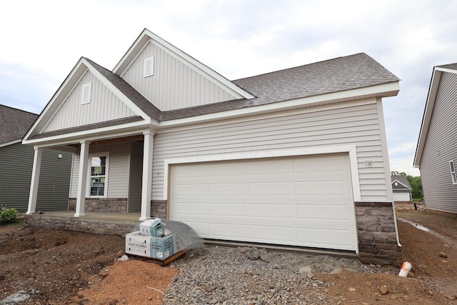 3046 Darby Downs Rd, Grove City, OH 43123 - view of front of home with covered porch, a shingled roof, board and batten siding, driveway, and a garage
