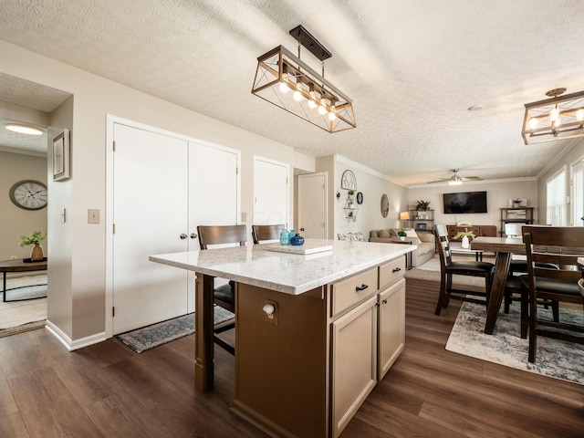 3538 Rosburg Dr, Columbus, OH 43228 - kitchen with dark wood-style flooring, a textured ceiling, a center island, light stone counters, and open floor plan