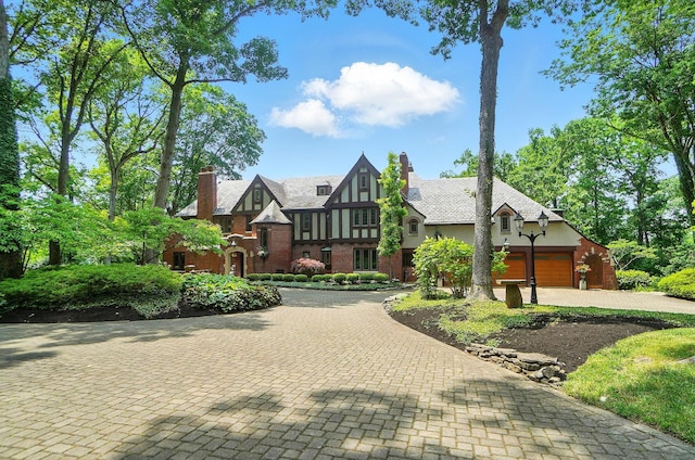 2475 Signal Hill Rd, Springfield, OH 45504 - english style home with stucco siding, decorative driveway, a chimney, and an attached garage