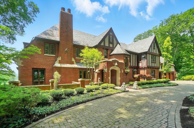 2475 Signal Hill Rd, Springfield, OH 45504 - tudor house with a high end roof, brick siding, a chimney, and driveway