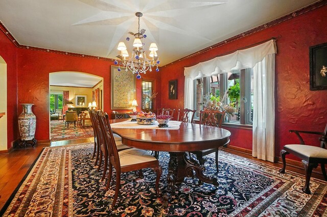 2475 Signal Hill Rd, Springfield, OH 45504 - dining room featuring arched walkways, wood finished floors, a chandelier, and healthy amount of natural light