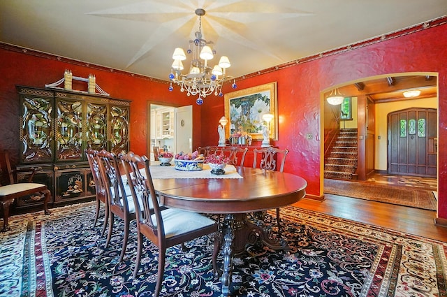 2475 Signal Hill Rd, Springfield, OH 45504 - dining area with arched walkways, a chandelier, a textured wall, hardwood / wood-style floors, and stairs
