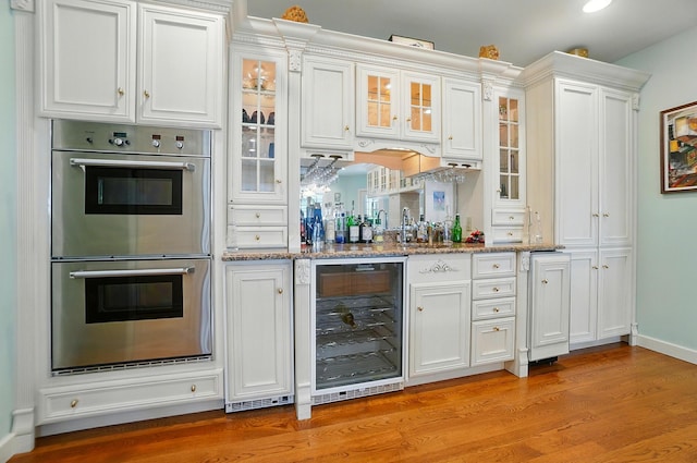 2475 Signal Hill Rd, Springfield, OH 45504 - indoor bar with beverage cooler, double oven, light wood-style flooring, and recessed lighting