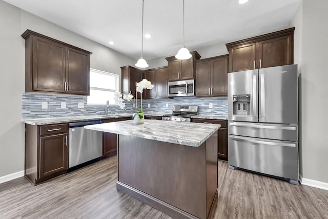 166 Rosewood Loop SE, Commercial Point, OH 43116 - kitchen with stainless steel appliances, dark brown cabinetry, light wood-style floors, tasteful backsplash, and recessed lighting