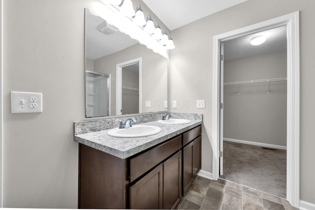 166 Rosewood Loop SE, Commercial Point, OH 43116 - bathroom featuring double vanity, a walk in closet, and an enclosed shower