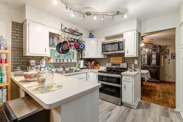 6103 Renner Rd, Columbus, OH 43228 - kitchen with stainless steel appliances, a peninsula, light countertops, decorative backsplash, and white cabinets