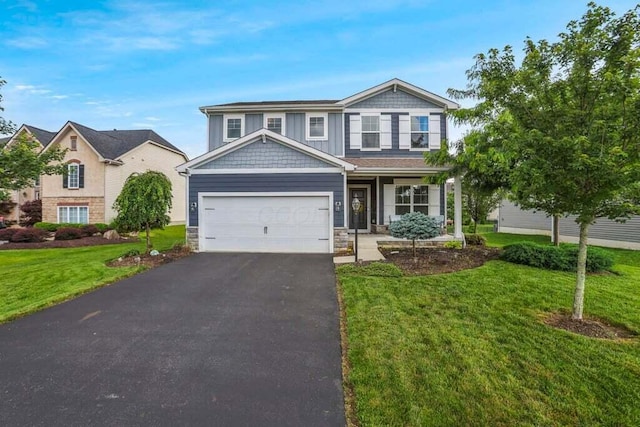 117 Sparrow Ct, Pickerington, OH 43147 - view of front of house with driveway, a front yard, stone siding, and an attached garage
