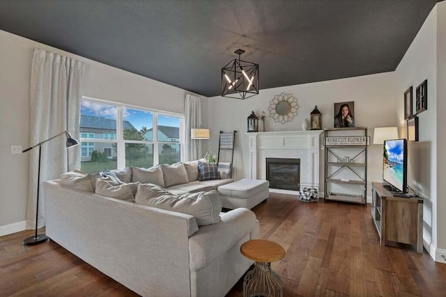117 Sparrow Ct, Pickerington, OH 43147 - living room with dark wood-style flooring, a chandelier, and a glass covered fireplace