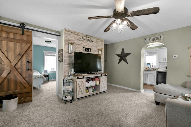 714 N Main St, Baltimore, OH 43105 - living area featuring ceiling fan, light carpet, arched walkways, and a barn door