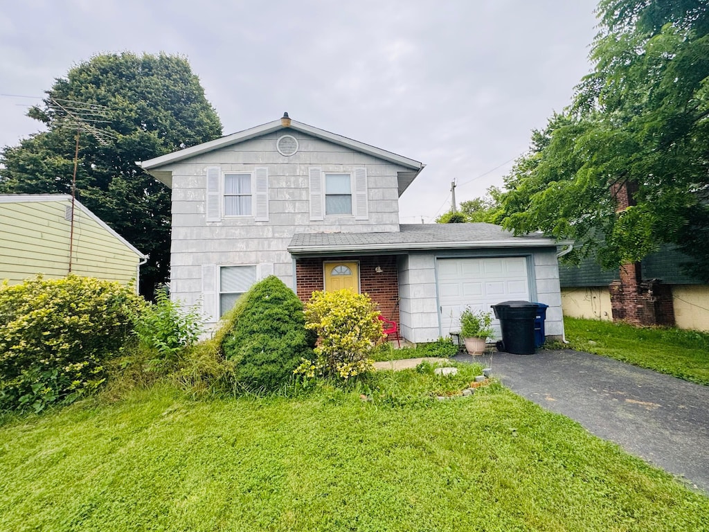 840 Obetz Rd, Columbus, OH 43207 - traditional-style house with driveway, an attached garage, a front yard, and brick siding
