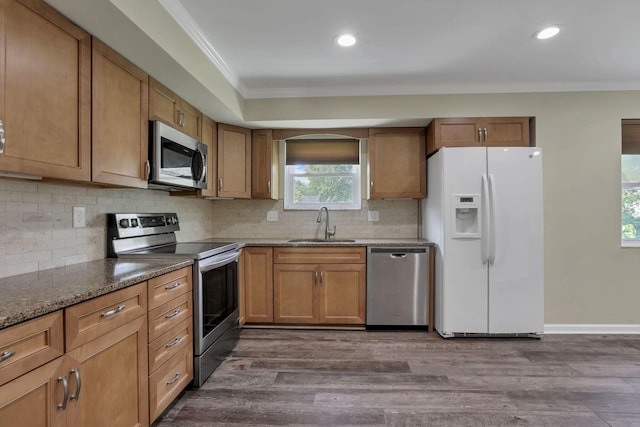 2809 Bella Via Ave, Columbus, OH 43231 - kitchen with appliances with stainless steel finishes, crown molding, tasteful backsplash, dark wood-type flooring, and brown cabinetry