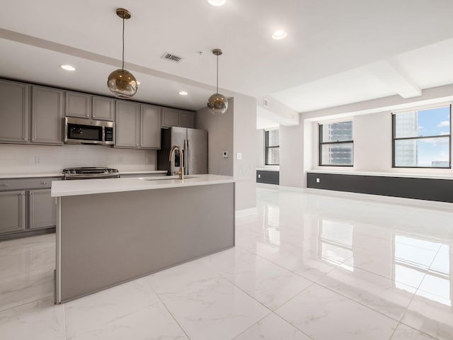 50 W Broad St Unit 2701, Columbus, OH 43215 - kitchen featuring appliances with stainless steel finishes, gray cabinetry, light countertops, a center island with sink, and light marble finish flooring