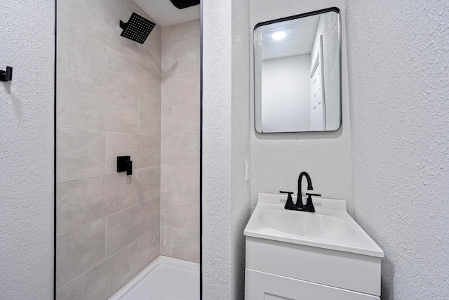 1430 Aberdeen Ave, Columbus, OH 43211 - bathroom with a tile shower, a textured wall, and vanity