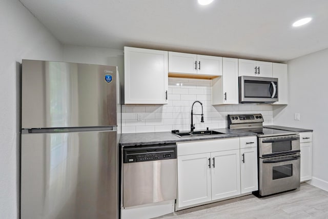 1430 Aberdeen Ave, Columbus, OH 43211 - kitchen with appliances with stainless steel finishes, dark countertops, white cabinetry, tasteful backsplash, and recessed lighting