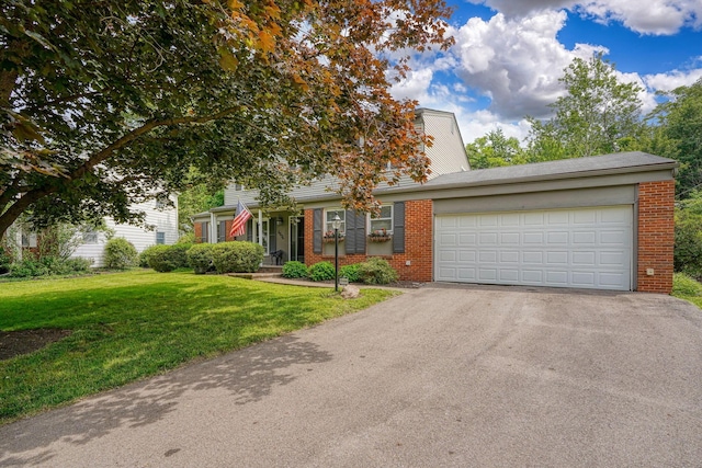 6676 Woodsedge Dr, Reynoldsburg, OH 43068 - view of front of home with brick siding, asphalt driveway, a front yard, and a garage