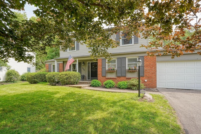 6676 Woodsedge Dr, Reynoldsburg, OH 43068 - view of front of property featuring a front lawn, brick siding, asphalt driveway, and a garage