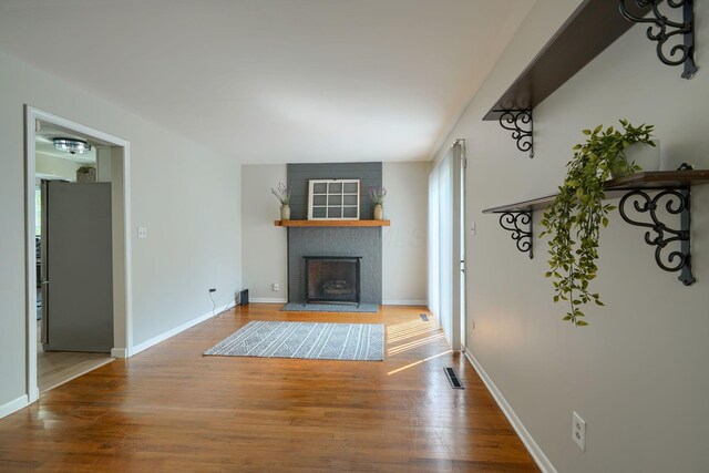6676 Woodsedge Dr, Reynoldsburg, OH 43068 - unfurnished living room featuring a fireplace with raised hearth and wood finished floors