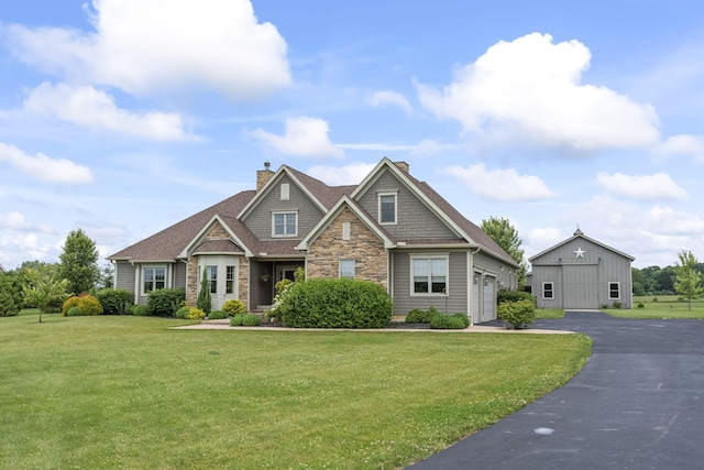 124 Dutch Ridge Way, Johnstown, OH 43031 - craftsman house featuring stone siding, a front yard, a garage, driveway, and a chimney