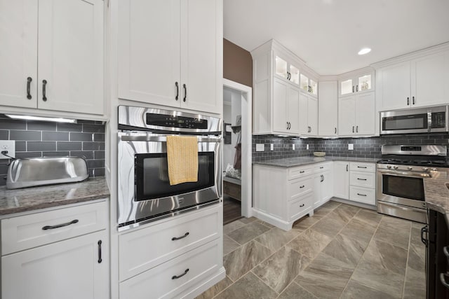 124 Dutch Ridge Way, Johnstown, OH 43031 - kitchen featuring appliances with stainless steel finishes, decorative backsplash, white cabinetry, light stone countertops, and glass insert cabinets