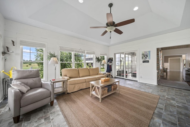 124 Dutch Ridge Way, Johnstown, OH 43031 - living room featuring a tray ceiling, stone finish flooring, a ceiling fan, and healthy amount of natural light