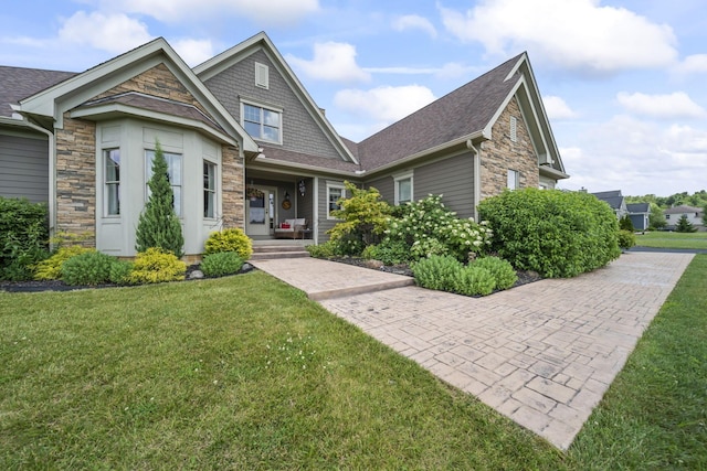 124 Dutch Ridge Way, Johnstown, OH 43031 - craftsman house with stone siding, a front yard, and a shingled roof