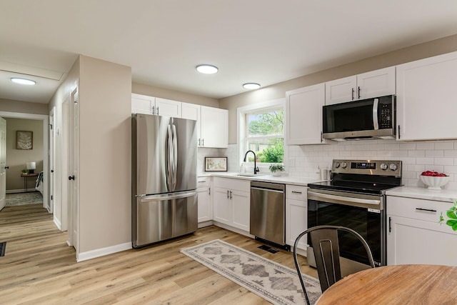 99 Ramona Ave, Newark, OH 43055 - kitchen featuring appliances with stainless steel finishes, white cabinets, light countertops, and light wood-style flooring