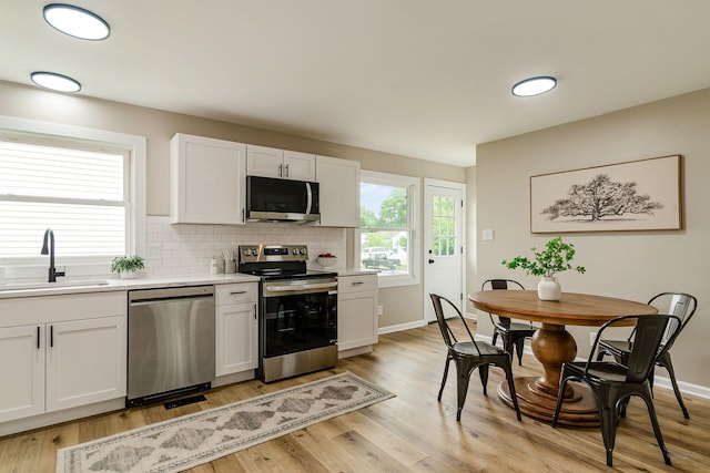 99 Ramona Ave, Newark, OH 43055 - kitchen with stainless steel appliances, light countertops, light wood-type flooring, and decorative backsplash