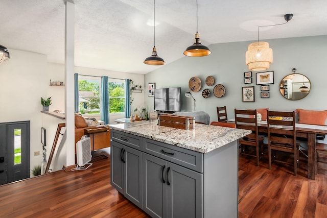 658 Academy Dr, Galloway, OH 43119 - kitchen featuring gray cabinetry, dark wood-style floors, hanging light fixtures, light stone countertops, and vaulted ceiling