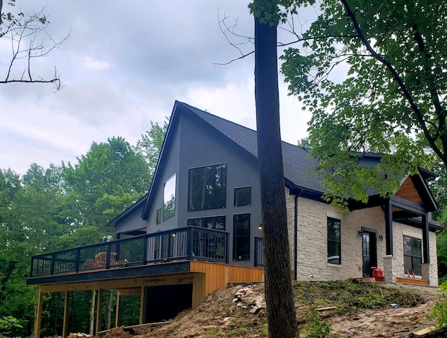 18358 Buckingham Rd, Logan, OH 43138 - rear view of property featuring stone siding, a wooden deck, a shingled roof, and stucco siding