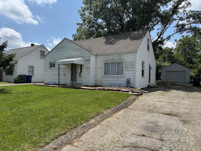 139 S Ashburton Rd, Columbus, OH 43213 - bungalow-style house featuring roof with shingles, a garage, a front lawn, an outdoor structure, and driveway