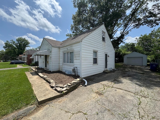 139 S Ashburton Rd, Columbus, OH 43213 - view of side of property with a detached garage, roof with shingles, an outdoor structure, and a yard