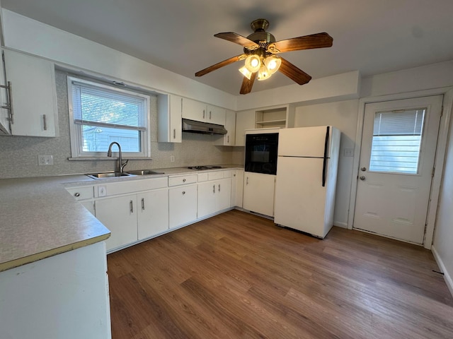 139 S Ashburton Rd, Columbus, OH 43213 - kitchen with freestanding refrigerator, black oven, under cabinet range hood, stovetop, and wood finished floors