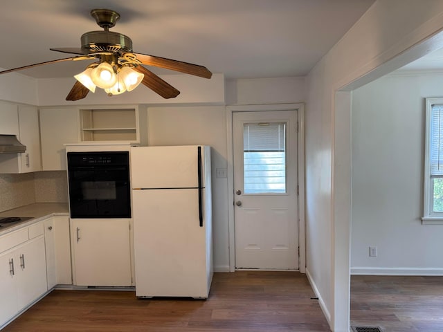 139 S Ashburton Rd, Columbus, OH 43213 - kitchen featuring freestanding refrigerator, black oven, under cabinet range hood, and dark wood finished floors