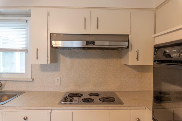 139 S Ashburton Rd, Columbus, OH 43213 - kitchen featuring stainless steel electric cooktop, under cabinet range hood, light countertops, oven, and white cabinetry