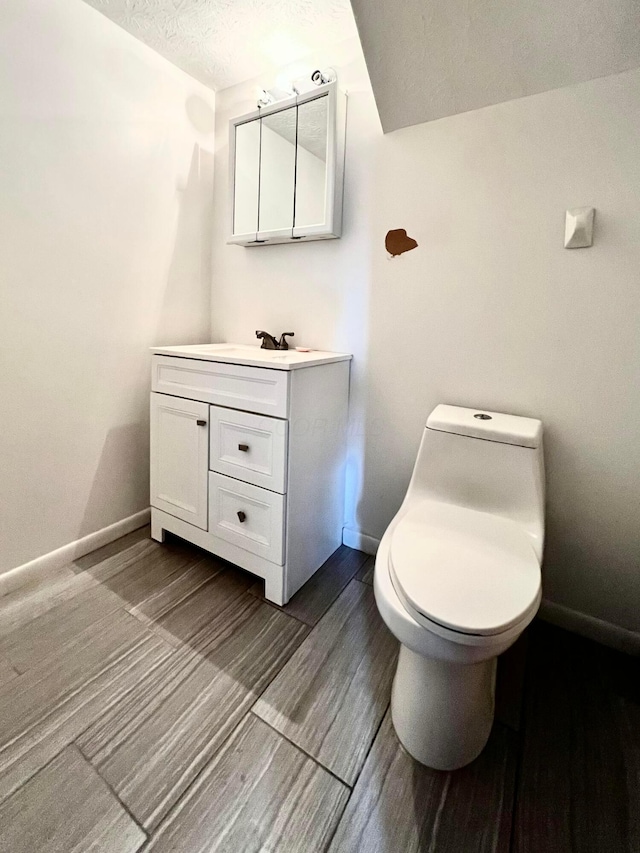5200 Williamsburg Cir, Hilliard, OH 43026 - half bathroom featuring vanity, a textured ceiling, and wood finished floors
