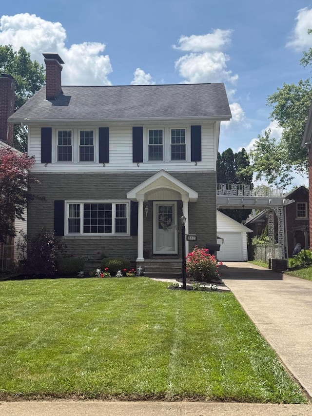 552 E 5th Ave, Lancaster, OH 43130 - view of front of property featuring a front lawn, a chimney, an outbuilding, and concrete driveway