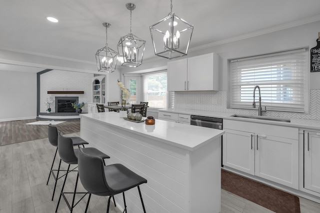 7732 Quarry Cliff Ct, Reynoldsburg, OH 43068 - kitchen with a kitchen island, tasteful backsplash, a chandelier, light countertops, and a fireplace