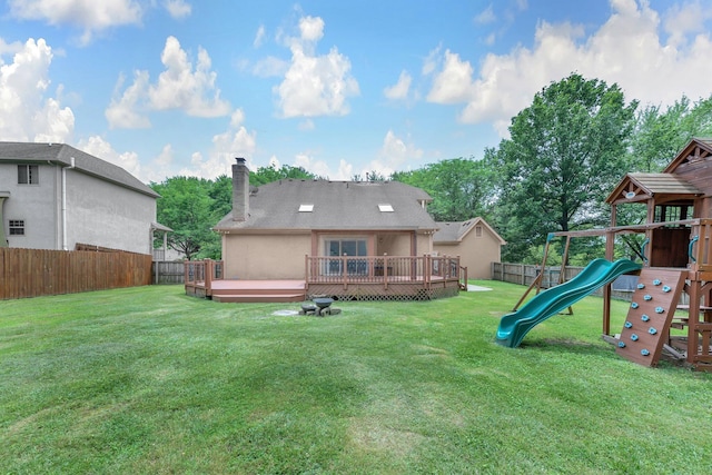 7732 Quarry Cliff Ct, Reynoldsburg, OH 43068 - rear view of house with a fenced backyard, a playground, a chimney, a wooden deck, and stucco siding
