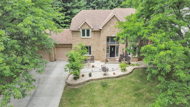 7732 Quarry Cliff Ct, Reynoldsburg, OH 43068 - view of front of house with concrete driveway, brick siding, a garage, a front lawn, and roof with shingles