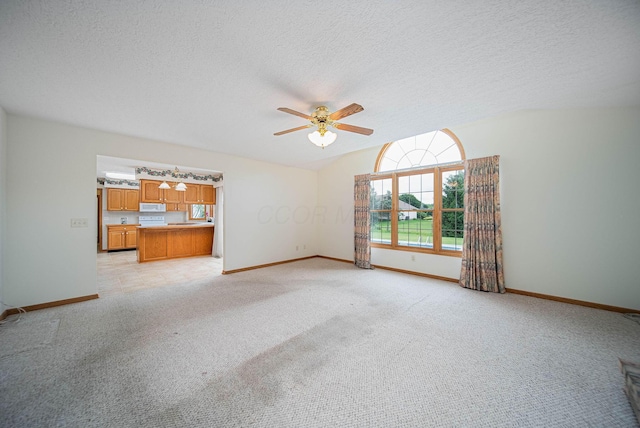 1948 Wendover Cir NE, North Canton, OH 44720 - unfurnished living room featuring ceiling fan, light colored carpet, a textured ceiling, and vaulted ceiling