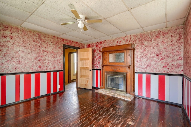 514 S Columbus St, Lancaster, OH 43130 - unfurnished living room with wallpapered walls, a drop ceiling, wood-type flooring, a glass covered fireplace, and ceiling fan