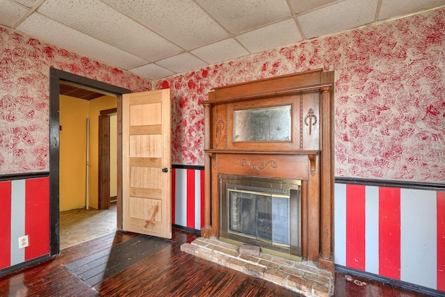 514 S Columbus St, Lancaster, OH 43130 - unfurnished living room featuring a drop ceiling, wallpapered walls, wood-type flooring, and a glass covered fireplace