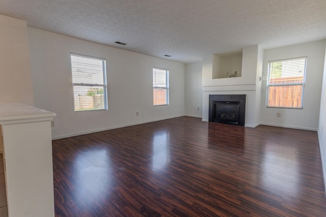 5480 Rothermund Dr, Canal Winchester, OH 43110 - unfurnished living room with plenty of natural light, dark wood-type flooring, a tile fireplace, and a textured ceiling