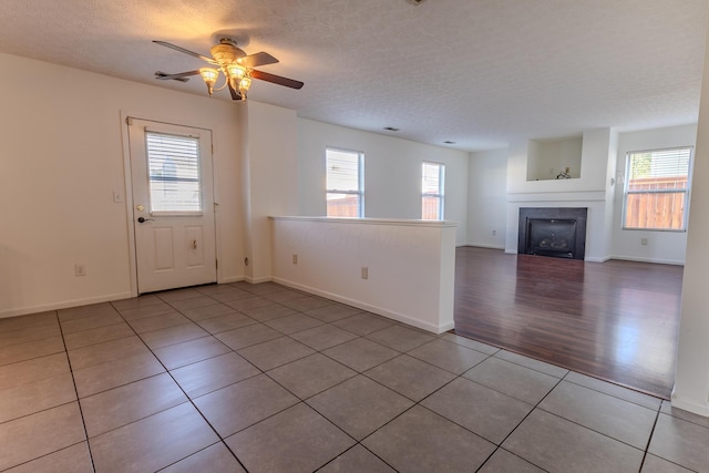 5480 Rothermund Dr, Canal Winchester, OH 43110 - unfurnished living room featuring plenty of natural light, a ceiling fan, a textured ceiling, and tile patterned flooring